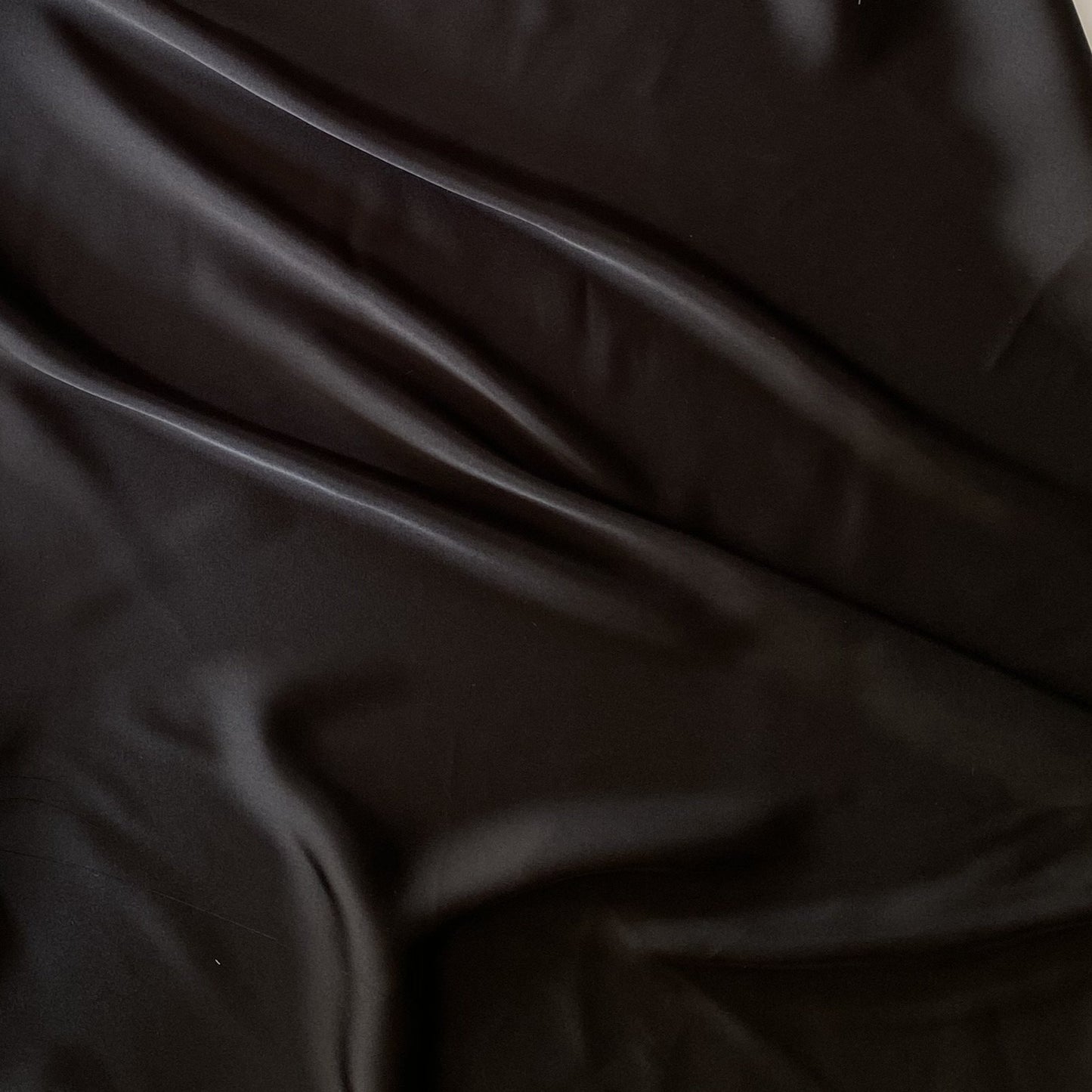 Deluxe displaying the black color version of a satin chiffon silk like pure polyester with fluid drape