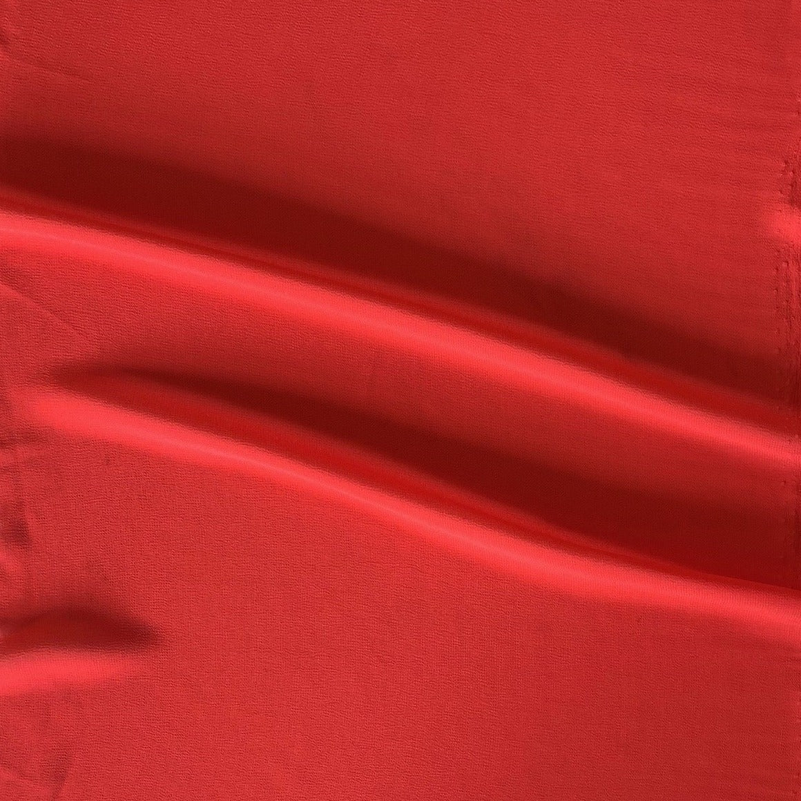 Deluxe displaying the scarlet color version of a satin chiffon silk like pure polyester with fluid drape