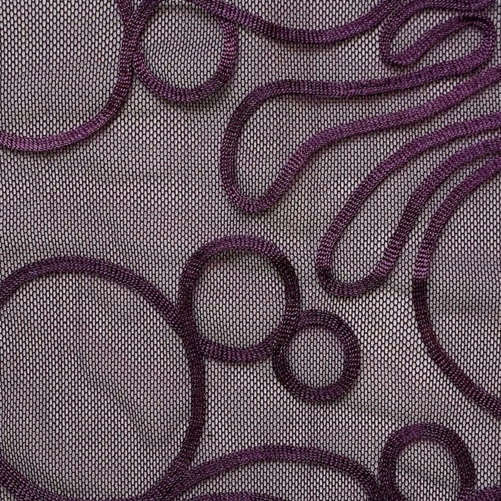 roulette presenting the plum color version of a polyester and rayon abstract circular Embroidery on fine sheer mesh closeup