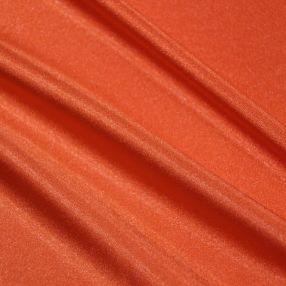 lola presenting the lava color version of a stretch light weight soft satin polyester with spandex