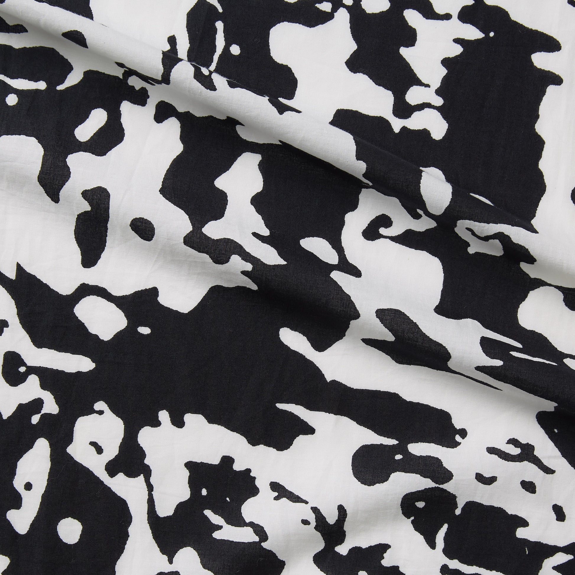 Displaying Calypso a black and white colored splotchy print on soft breathable and lightweight pure cotton featuring moderate drape