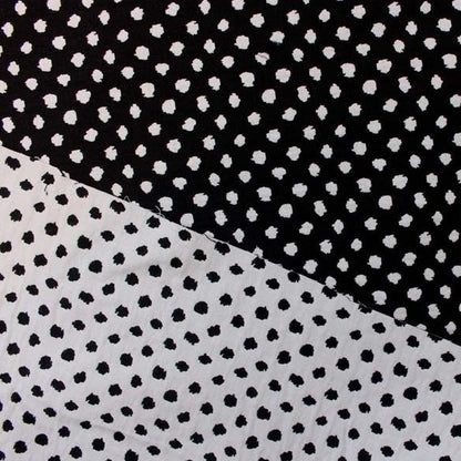 meteor featuring both sides of a stretchable, reversible, cotton poly with spandex blend featuring a dobby weave  with spotty blotches showing both sides of white on black and black on white