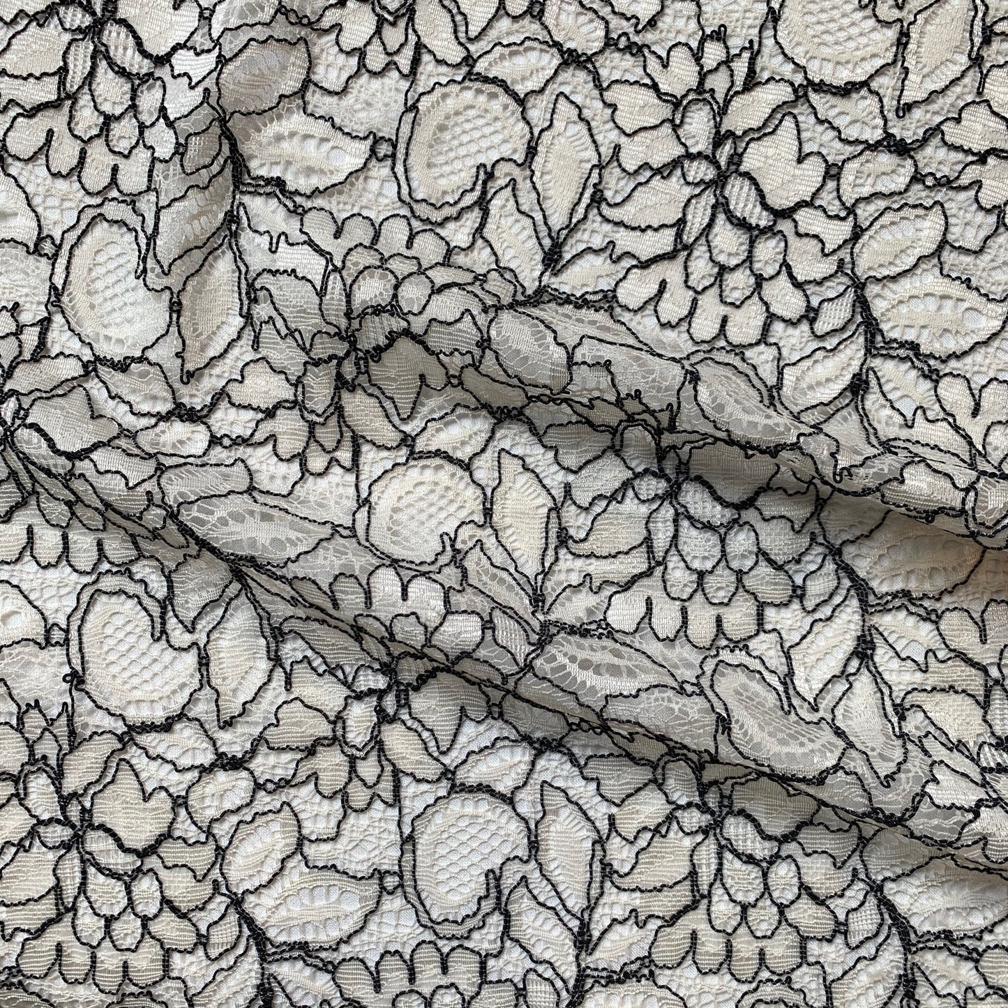 piccadilly displaying the ivory color version of a rayon bland rochelle antique designed lace with double scalloped edge on a rayon and nylon blend