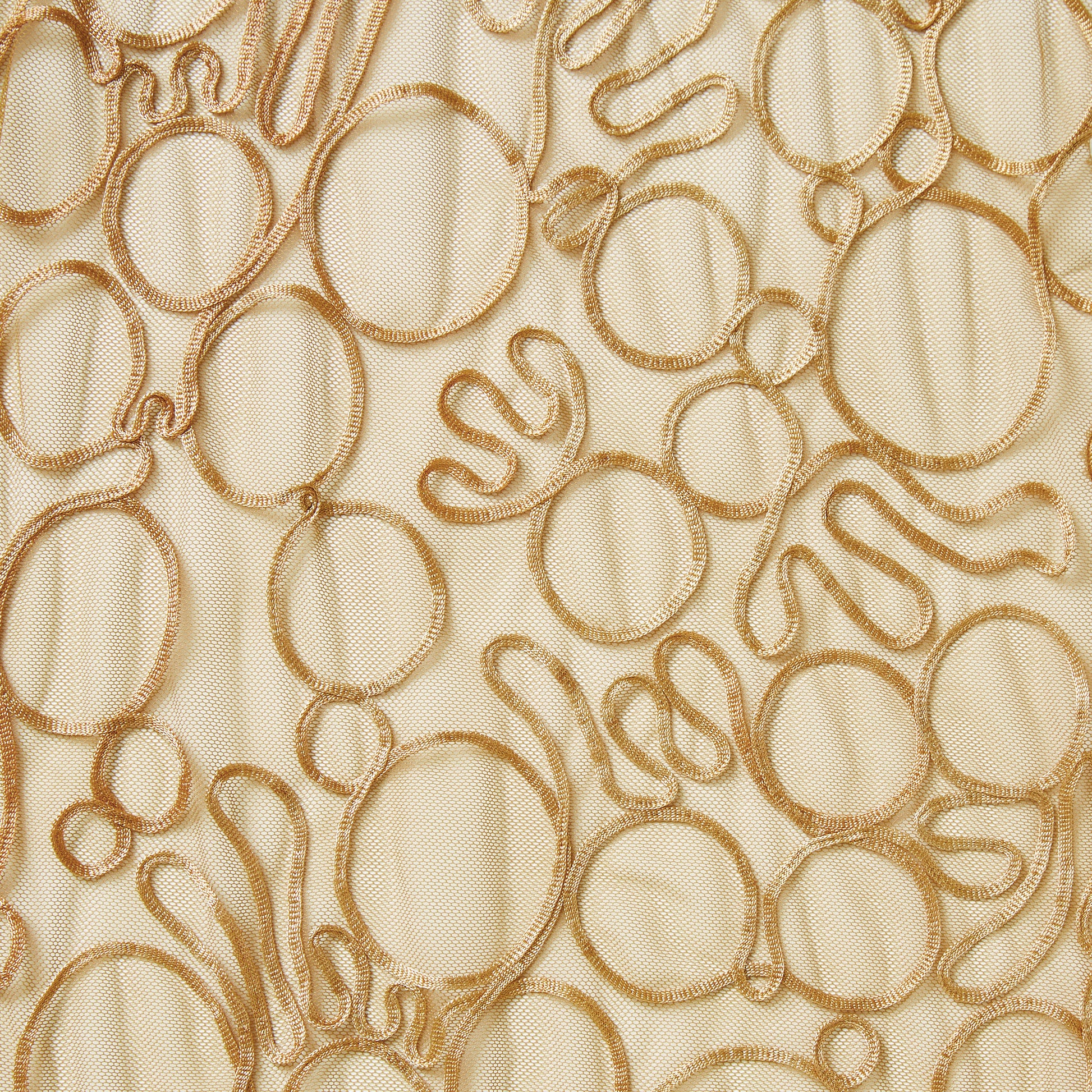 roulette presenting the tan color version of a polyester and rayon abstract circular Embroidery on fine sheer mesh