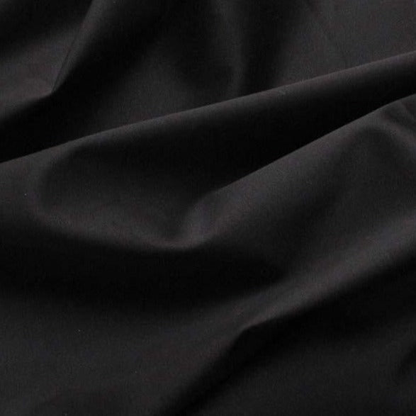 Displaying Sateen Cotton and Spandex a  Black colored Stretch Sateen with moderate drape showing folds