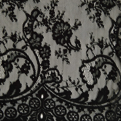 Showing tivoli the black color version of an antique panelled lace with eyelash detailing on a nylon, rayon and cotton blend with metallic print