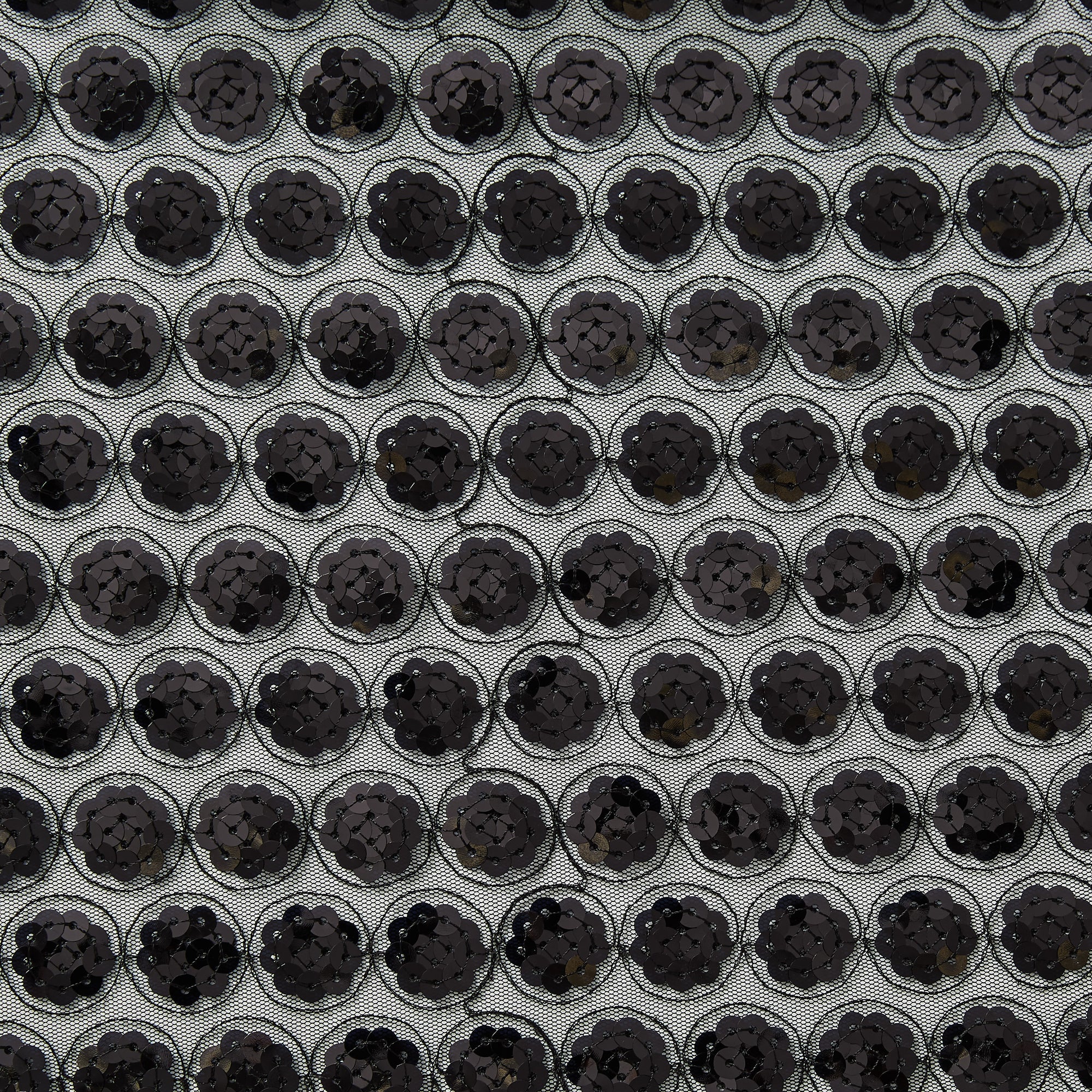 Illustrating vegas a black colored Sequinned embroidery in regurlar spots on a sheer black polyester mesh  base